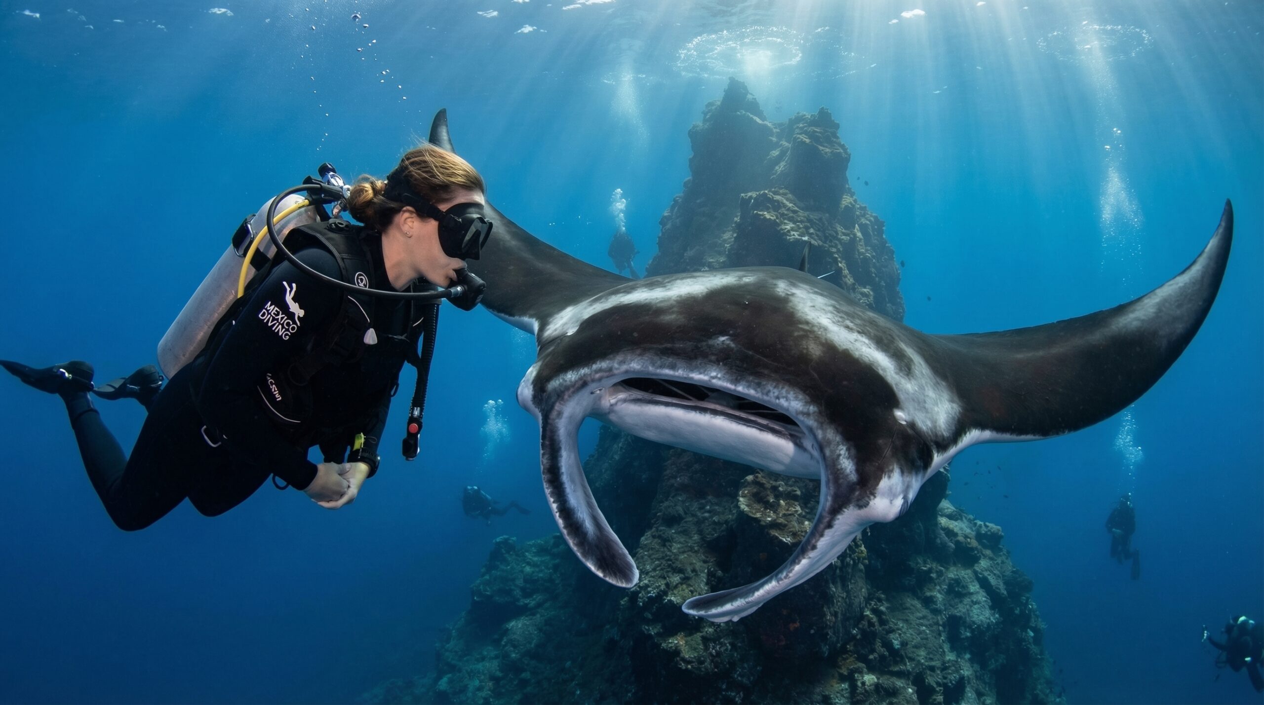 Buceadora profesional de Mexico Diving frente a una manta gigante oceánica en el sitio El Boiler, Isla San Benedicto